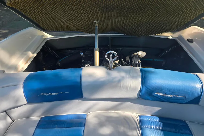 Slide: The Image of 1987 Sea Ray Pachanga 22 boat interior with engine compartment open, showcasing blue and white seating. - 26