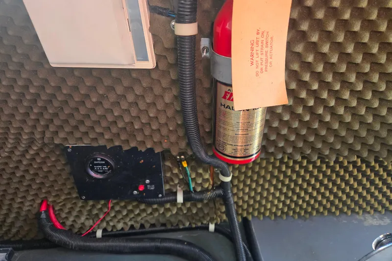 Slide: The Image of 1987 Sea Ray Pachanga 22 engine compartment with fire extinguisher and control panel. - 28