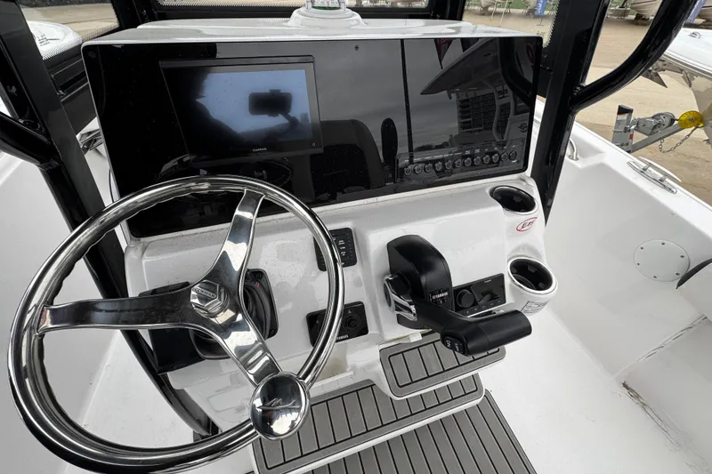 Slide: The Image of 2026 Tidewater 220 LXF boat helm with steering wheel and control panel. - 10