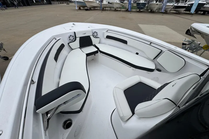 Slide: The Image of 2026 Tidewater 220 LXF boat interior with white and black seating, docked outdoors. - 13