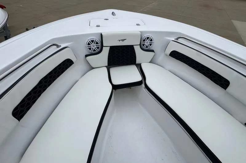 Slide: The Image of 2026 Tidewater 220 LXF boat interior with white cushioned seating and speakers. - 14