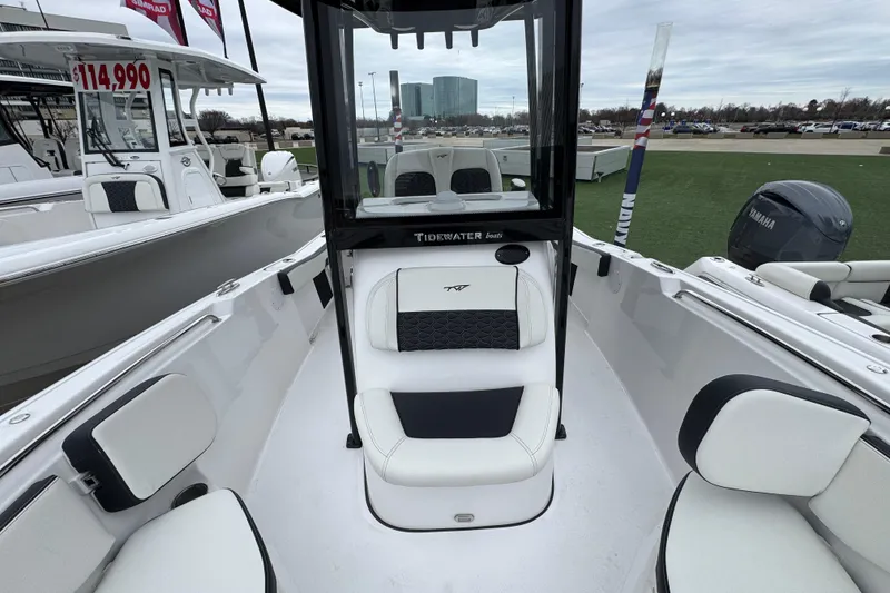 Slide: The Image of 2026 Tidewater 220 LXF boat interior with seating and console, displayed outdoors. - 16