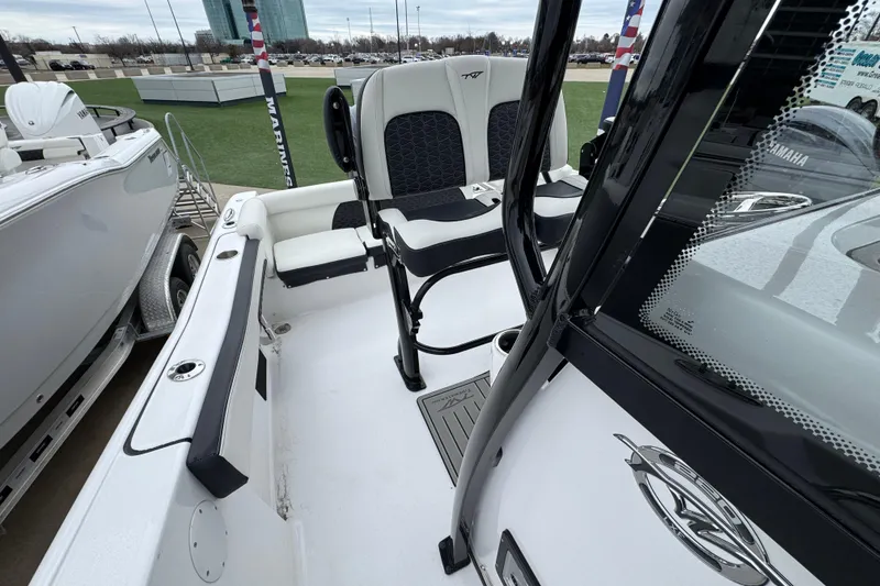 Slide: The Image of 2026 Tidewater 220 LXF boat interior with seating and console, displayed outdoors. - 17