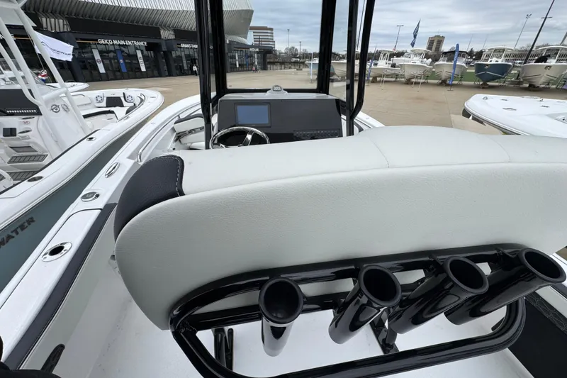 Slide: The Image of 2026 Tidewater 220 LXF boat interior with helm and rod holders at a marina. - 7