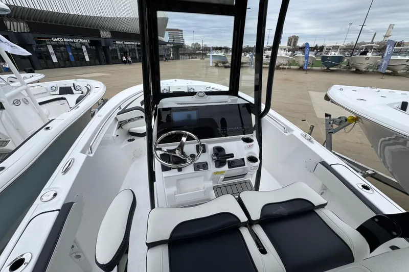 Slide: The Image of 2026 Tidewater 220 LXF boat interior with modern helm and seating at a marina display. - 8