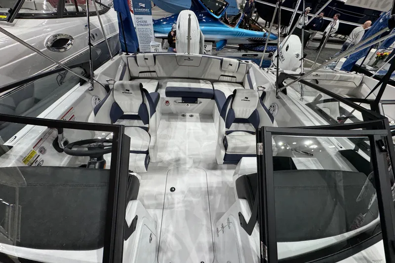 Slide: The Image of 2026 Stingray 20 SBX boat interior with seating and steering wheel at a boat show. - 12