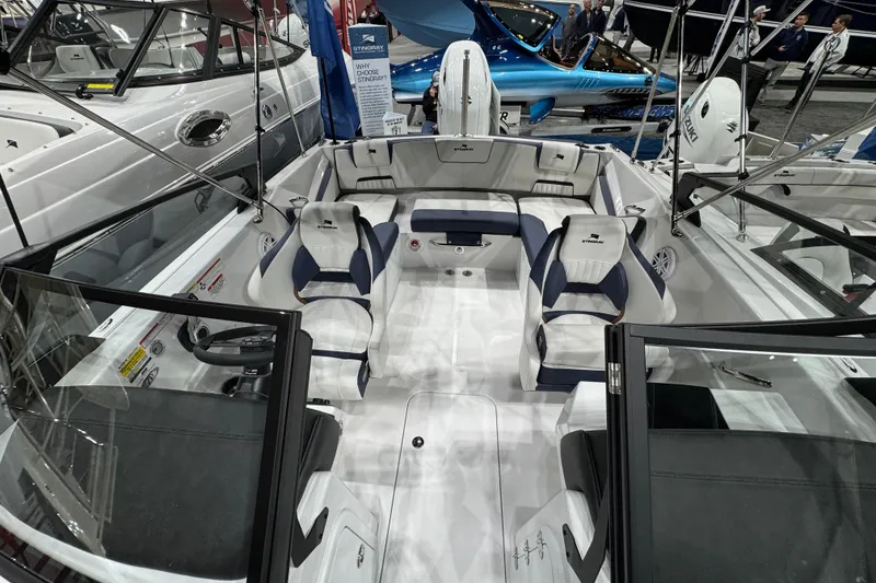 Slide: The Image of 2026 Stingray 20 SBX boat interior with seating and steering wheel at a boat show. - 13