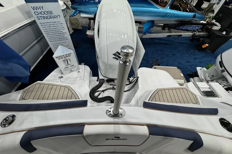 Slide: The Image of 2026 Stingray 20 SBX boat display with engine and promotional signage at a boat show. - 2