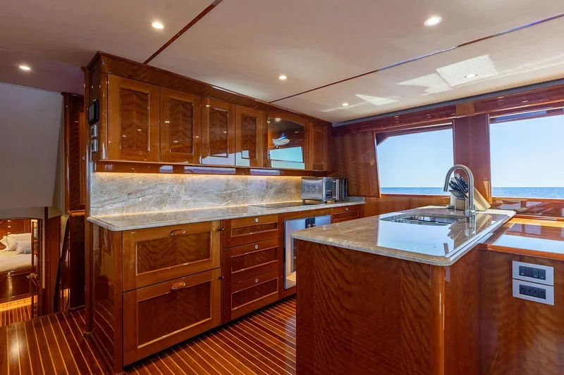 Slide: The Image of Luxurious kitchen interior of 2016 Viking 82 Sky Bridge yacht with wooden cabinetry and ocean view. - 18