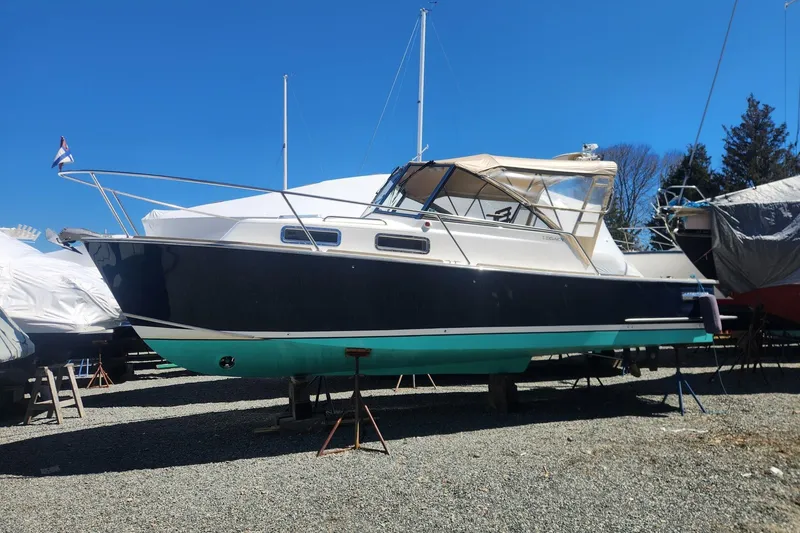The Image of 2004 Legacy 28ft Express boat on dry dock under clear blue sky. - 0