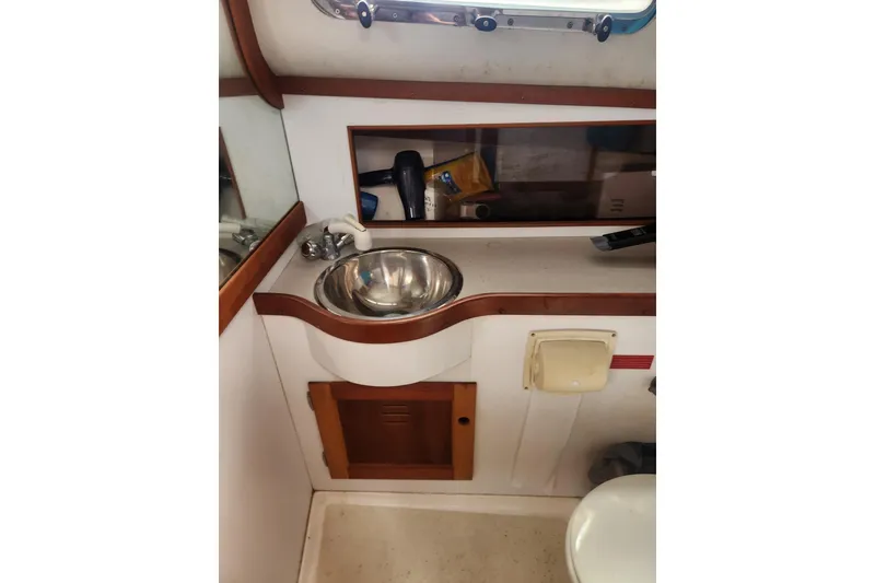 Slide: The Image of 2004 Legacy 28ft boat bathroom with sink, mirror, and storage cabinet. - 19
