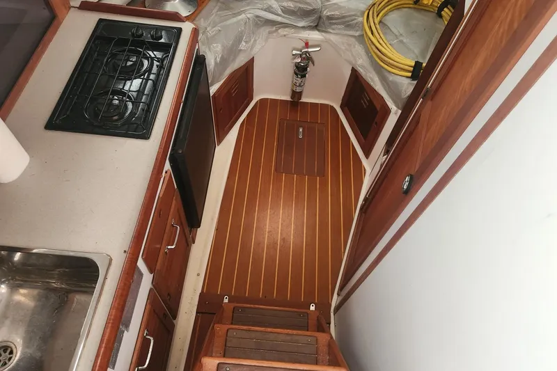 Slide: The Image of Interior of 2004 Legacy 28ft boat with kitchenette and wooden flooring. - 21