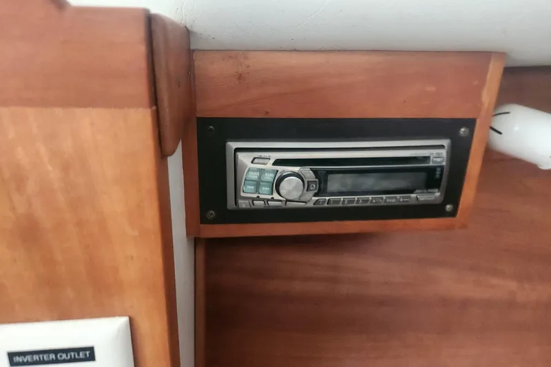 Slide: The Image of 2004 Legacy 28ft boat interior with built-in stereo system and inverter outlet. - 23