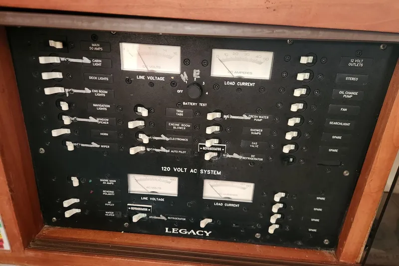 Slide: The Image of Electrical control panel of a 2004 Legacy 28ft boat, featuring switches and gauges. - 24