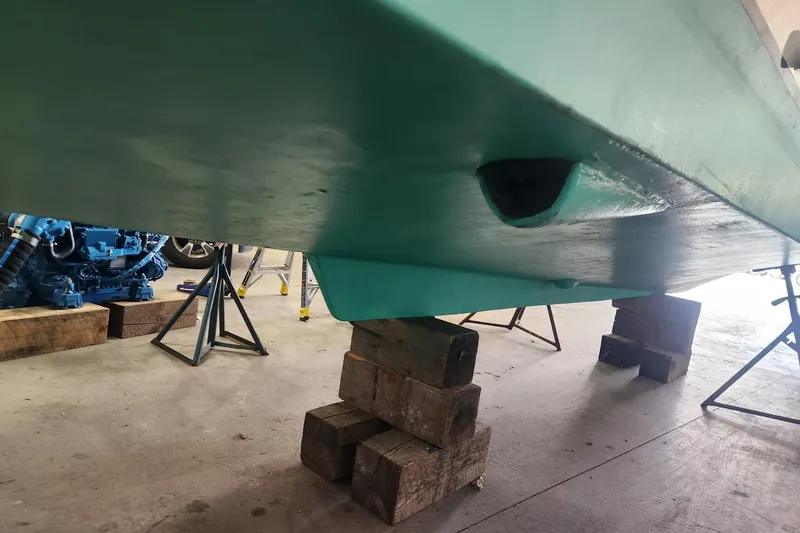 Slide: The Image of 2004 Legacy 28ft boat hull on blocks in a workshop setting. - 31