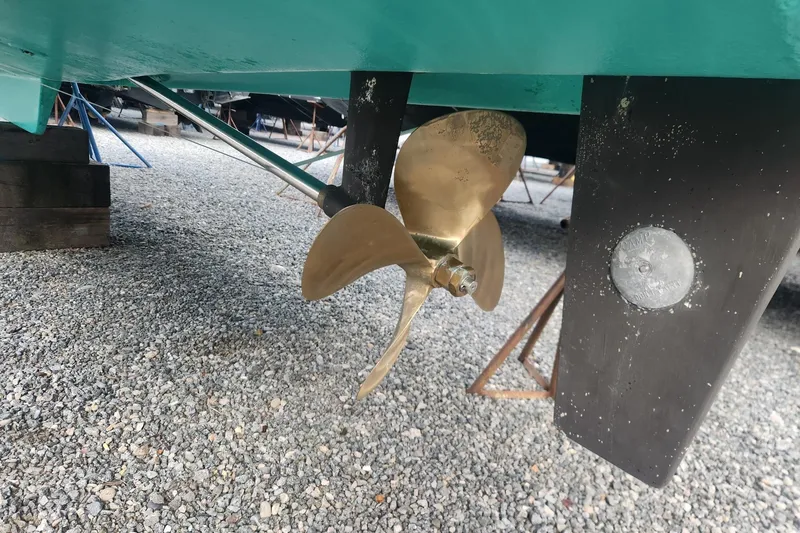 Slide: The Image of Propeller of 2004 Legacy 28ft boat on gravel surface, showcasing bronze finish. - 32