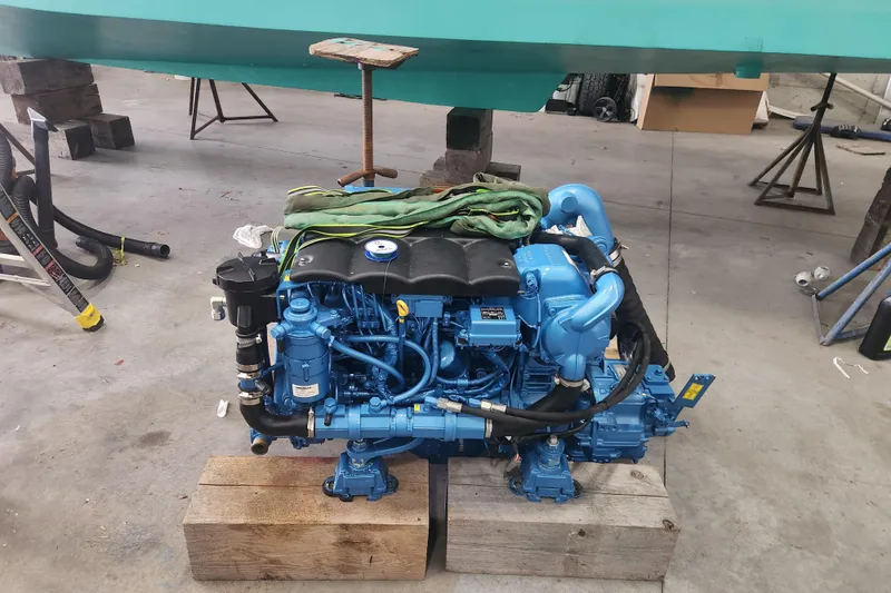 Slide: The Image of Blue marine engine on wooden blocks, Legacy 28ft 2004 model, in a workshop setting. - 33