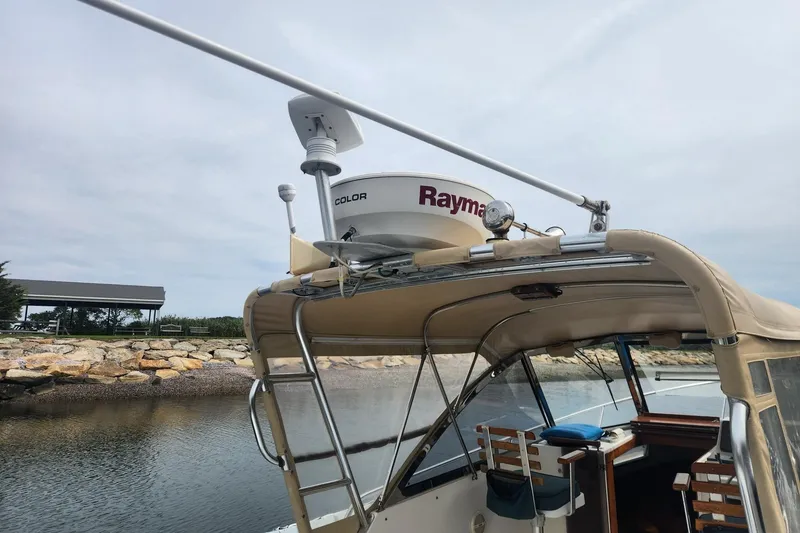 Slide: The Image of 2004 Legacy 28ft boat with Raymarine radar, docked by a rocky shoreline. - 4