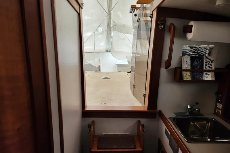 Slide: The Image of Interior view of a 2004 Legacy 28ft boat, featuring a compact kitchen area. - 41