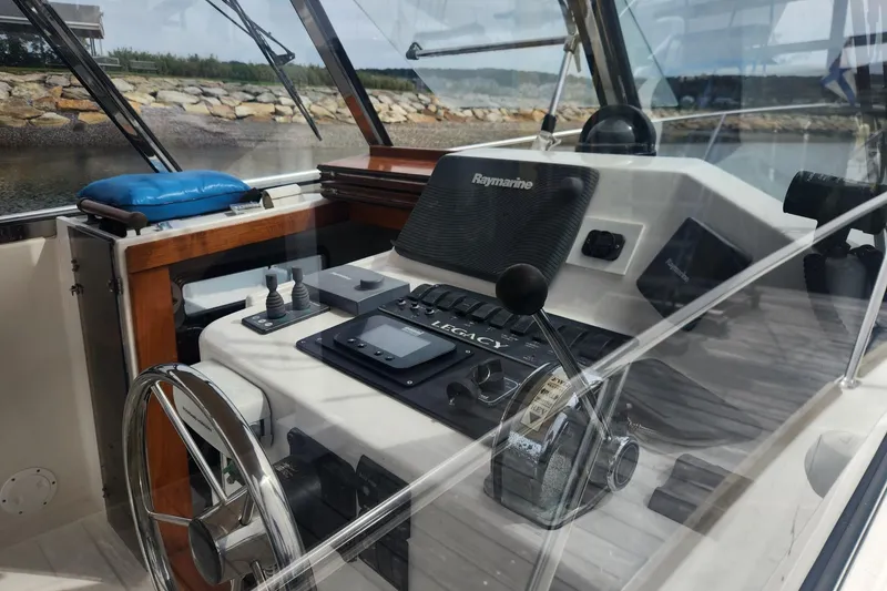 Slide: The Image of Interior view of a 2004 Legacy 28ft boat cockpit with steering wheel and navigation controls. - 8