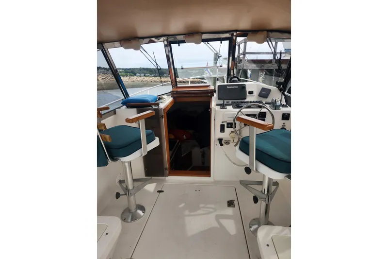Slide: The Image of Interior view of a 2004 Legacy 28ft boat cockpit with steering and seating. - 9