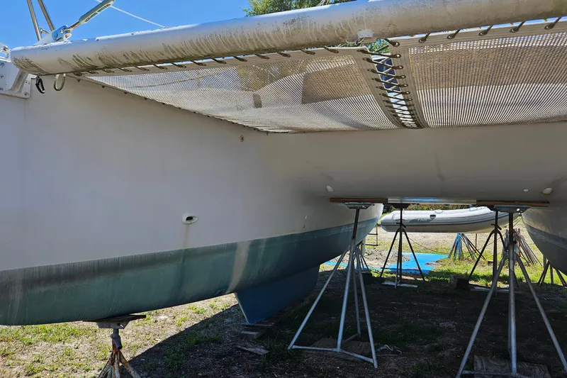 Slide: The Image of 1996 PDQ 32 LRC catamaran on stands, showing hull and netting details. - 10