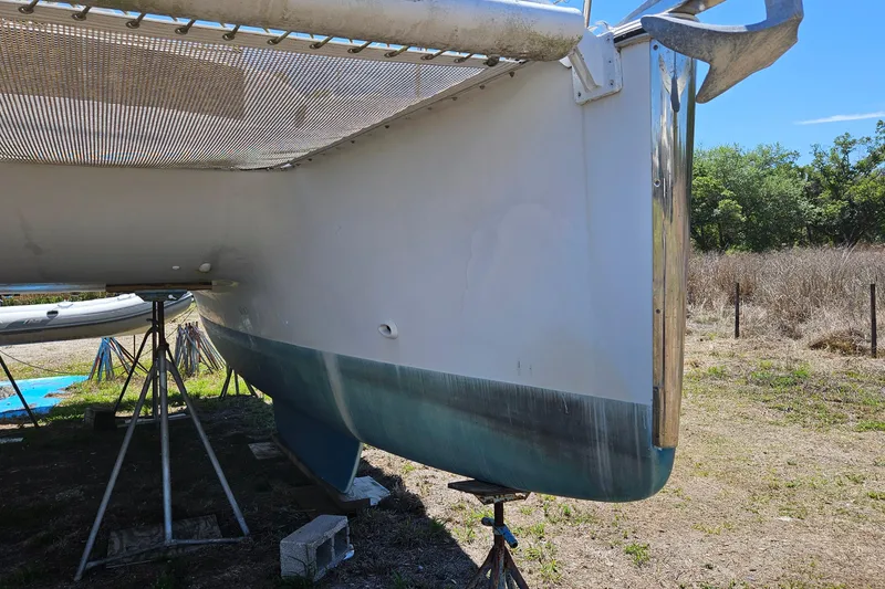 Slide: The Image of 1996 PDQ 32 LRC catamaran on stands, showing hull and anchor detail. - 12