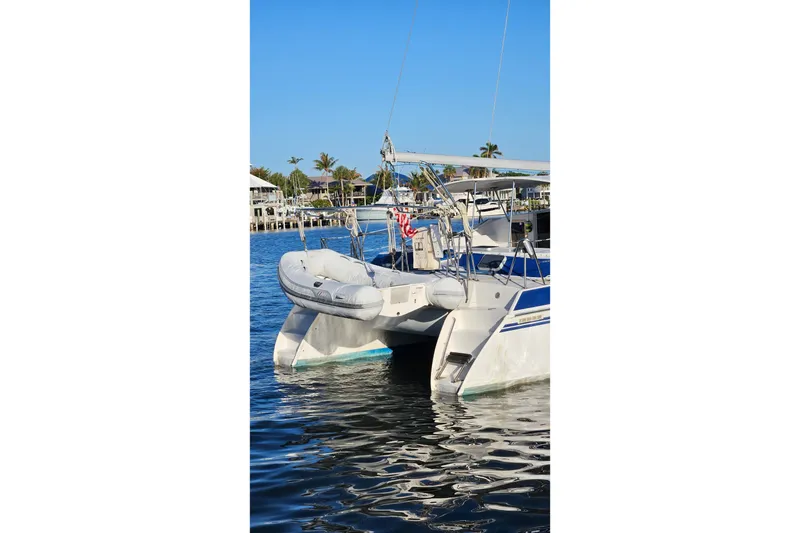Slide: The Image of Catamaran PDQ 32 LRC 1996 docked in sunny marina with inflatable dinghy. - 2