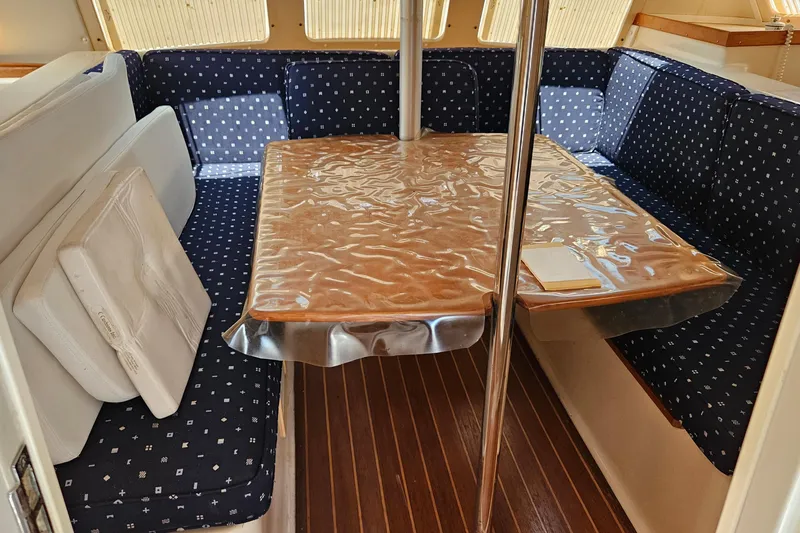 Slide: The Image of Cozy dining area in 1996 PDQ 32 LRC boat with cushioned seating and wooden table. - 21