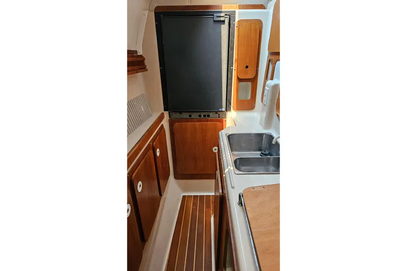 Slide: The Image of Compact galley kitchen in 1996 PDQ 32 LRC boat with wooden cabinets and dual sink. - 22