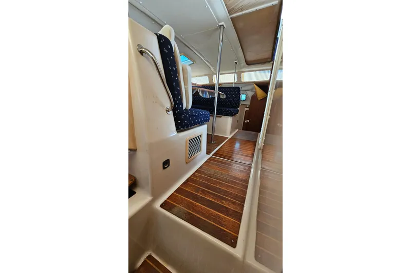 Slide: The Image of Interior of 1996 PDQ 32 LRC boat with wooden flooring and blue upholstered seating. - 28