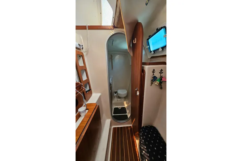 Slide: The Image of Interior of 1996 PDQ 32 LRC boat featuring compact bathroom and wooden accents. - 29