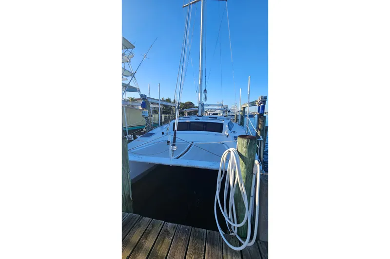 Slide: The Image of 1996 PDQ 32 LRC catamaran docked at marina under clear blue sky. - 3