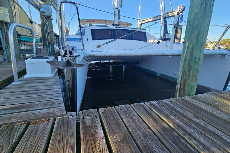 Slide: The Image of 1996 PDQ 32 LRC catamaran docked at a wooden marina pier. - 5