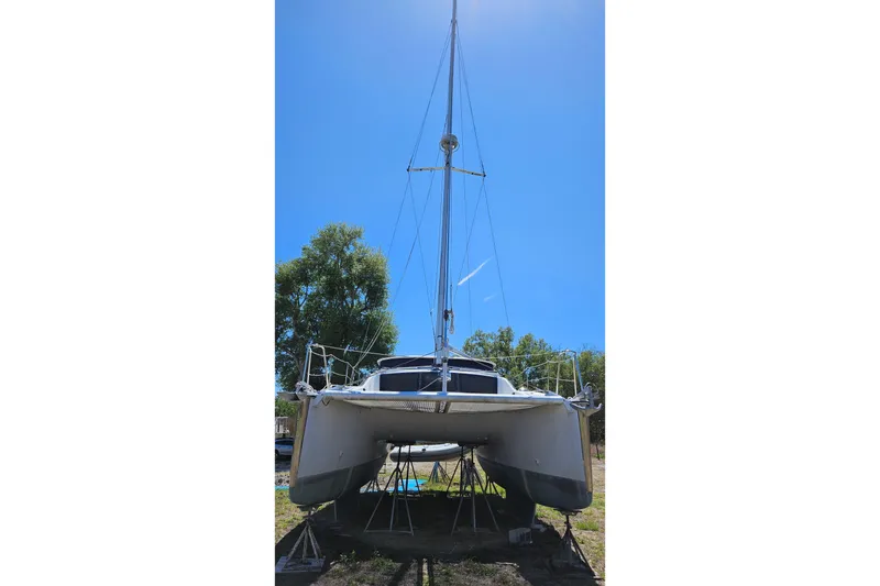Slide: The Image of 1996 PDQ 32 LRC catamaran on stands, under clear blue sky. - 9