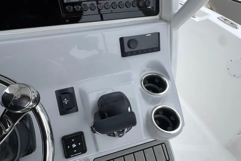 Slide: The Image of Control panel of 2026 Tidewater 232 CC Adventure boat with steering wheel and cup holders. - 10