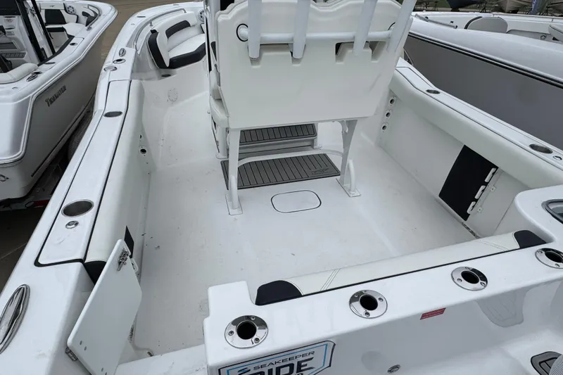 Slide: The Image of 2026 Tidewater 232 CC Adventure boat interior with seating and rod holders. - 3