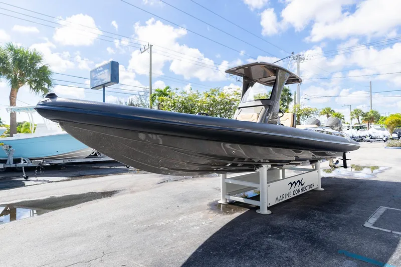 Slide: The Image of 2023 Airship 310 boat displayed at Marine Connection dealership under clear skies. - 10