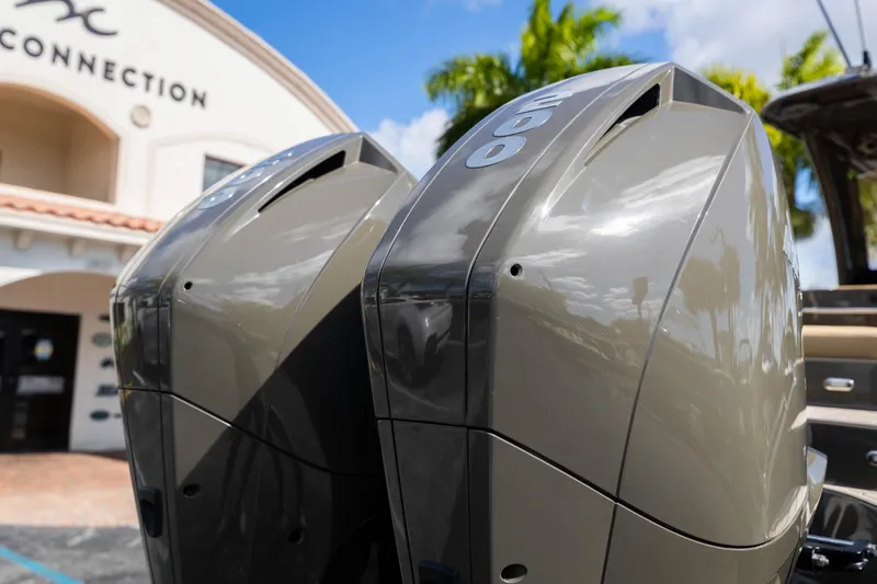 Slide: The Image of Twin outboard motors on a 2023 Airship 310 boat, with a building in the background. - 14