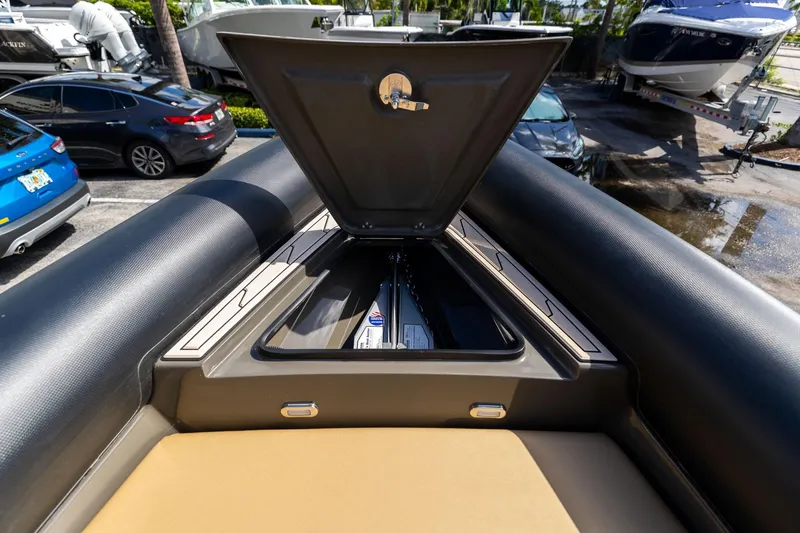 Slide: The Image of Open storage compartment on 2023 Airship 310 boat, parked near vehicles and other boats. - 37