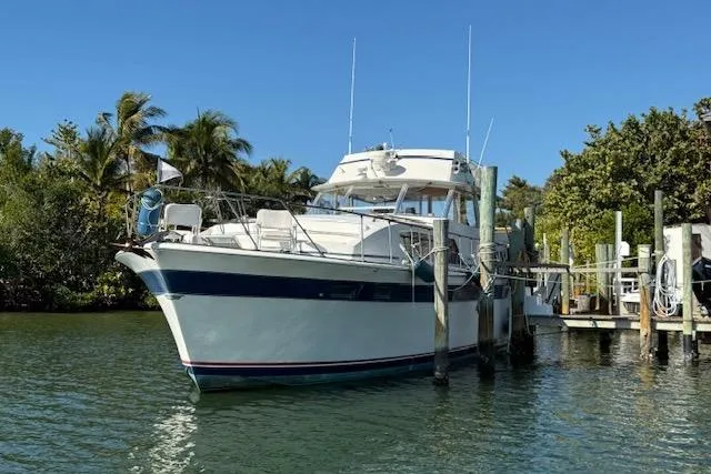 The Image of 1972 Chris-Craft boat docked in a tropical marina with palm trees and clear skies. - 0