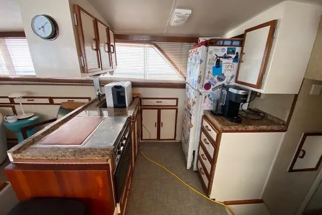 Slide: The Image of 1972 Chris-Craft boat kitchen with wooden cabinets, appliances, and a refrigerator. - 19
