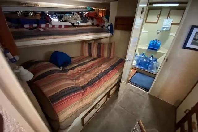 Slide: The Image of 1972 Chris-Craft boat interior with striped bedding and compact storage space. - 24
