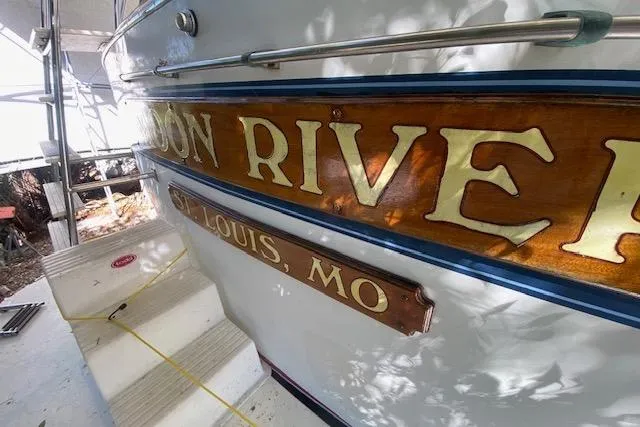 Slide: The Image of 1972 Chris-Craft boat with "St. Louis, MO" and "RIVER" signage on wooden panel. - 5