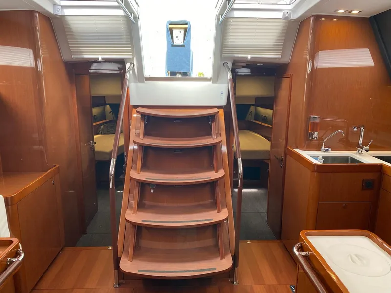 Slide: The Image of Interior of 2016 Beneteau Oceanis 60 yacht with wooden stairs and modern kitchen area. - 16