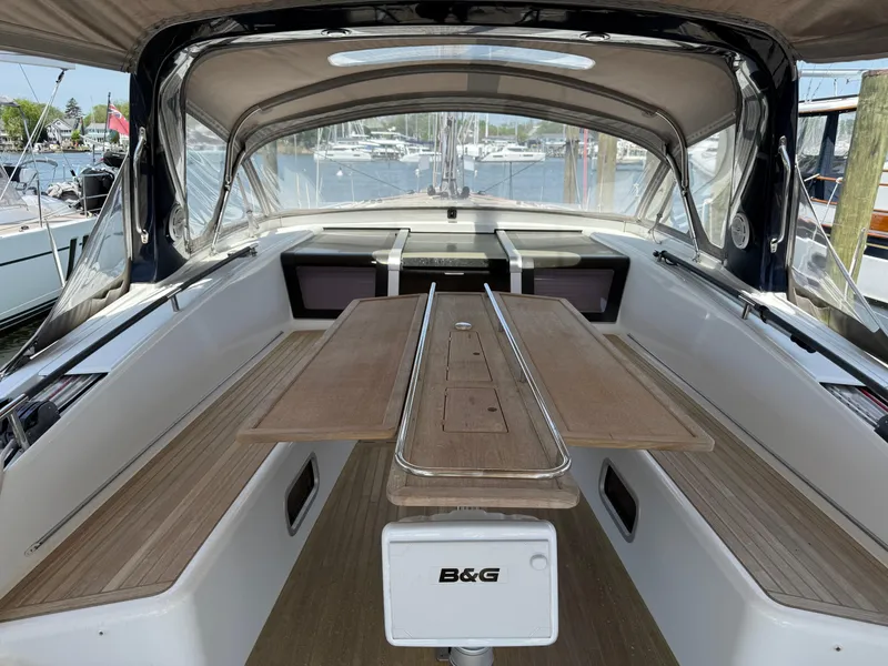 Slide: The Image of Spacious cockpit of 2016 Beneteau Oceanis 60 sailboat with wooden seating and table. - 38