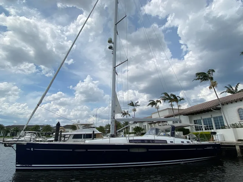 Slide: The Image of 2016 Beneteau Oceanis 60 yacht docked by waterfront homes under cloudy sky. - 44