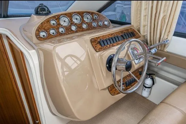 Slide: The Image of 2002 Bayliner 3488 Avanti helm with gauges, steering wheel, and control levers. - 14