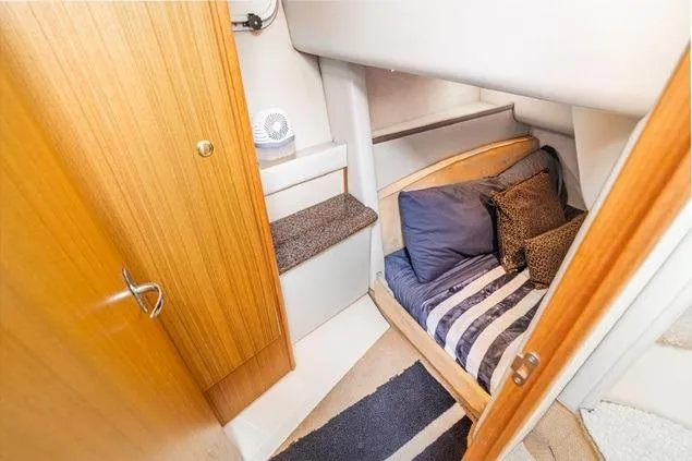 Slide: The Image of 2002 Bayliner 3488 Avanti cabin interior with cozy bed and wooden door. - 19