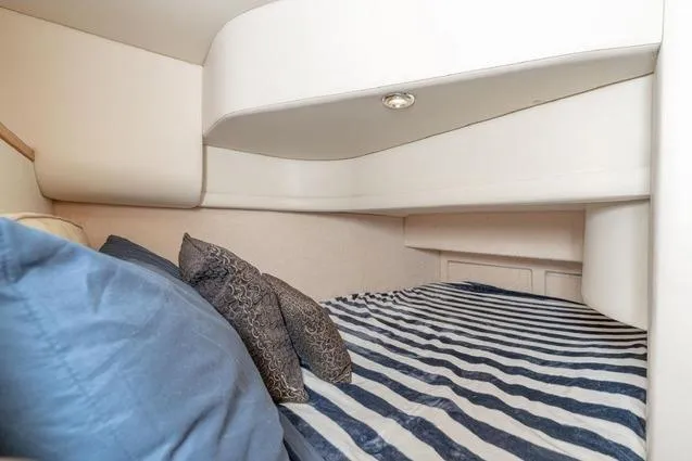 Slide: The Image of Cozy cabin interior of 2002 Bayliner 3488 Avanti with striped bedding and pillows. - 20